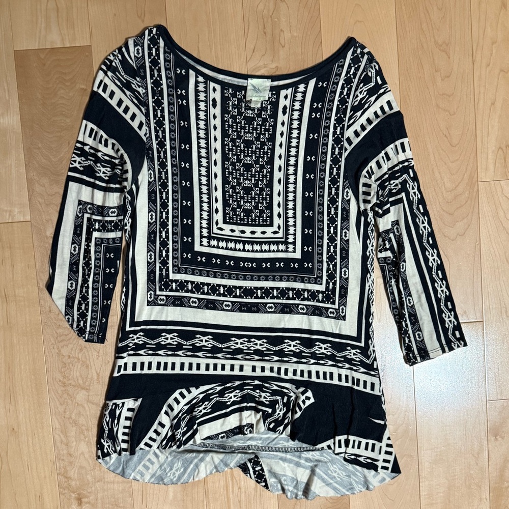 Quarter sleeve black and tan printed shirt with peplum detail on bottom.